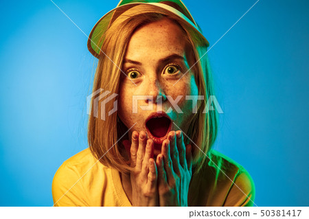 Beautiful woman in neon light isolated on blue studio background Beautiful woman in neon light isolated on blue studio background 50381417