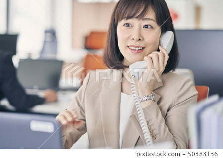 婦女在辦公室打電話 婦女在辦公室打電話 50383136