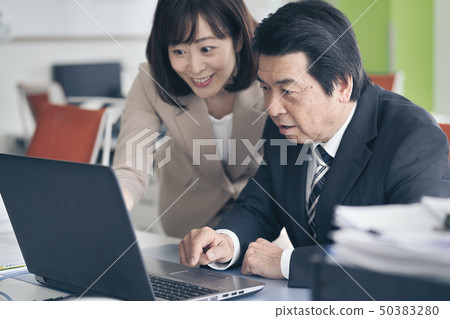 Woman teaching laptop to boss Woman teaching laptop to boss 50383280
