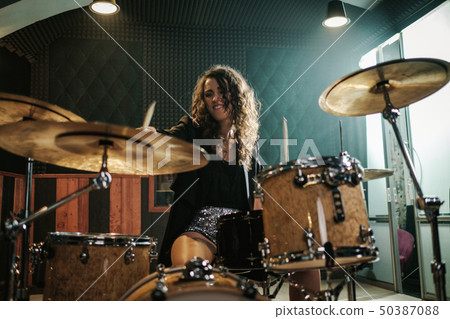 Woman playing drums during music band rehearsal Woman playing drums during music band rehearsal 50387088