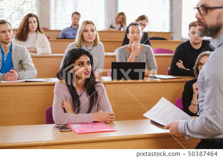 Lecturer and multinational group of students in an auditorium 50387464