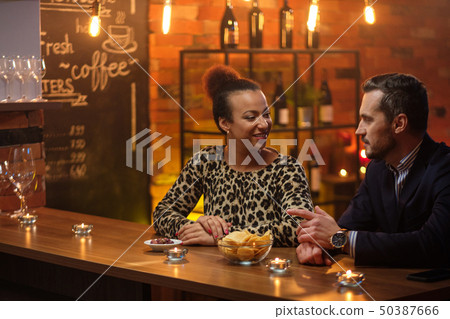 Couple talking behind bar counter in a cafe Couple talking behind bar counter in a cafe 50387666