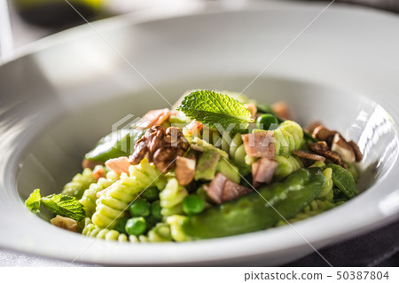 Fusilli pasta with green peas ham and walnuts. Fusilli pasta with green peas ham and walnuts. 50387804