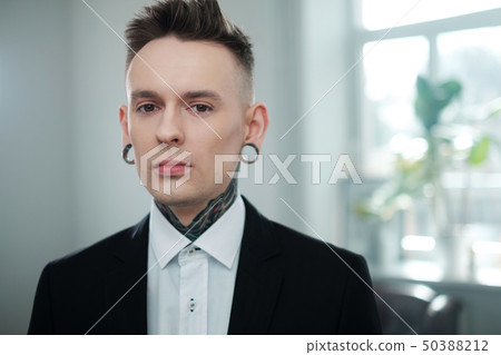Portrait of alternative model with earplugs and tattoo 50388212