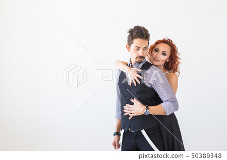 Social dance, bachata, kizomba, people concept - Young pretty woman in pink dress and man dancing Social dance, bachata, kizomba, people concept - Young pretty woman in pink dress and man dancing 50389348