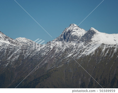 The snowy peaks of the mountains on a clear day 50389959