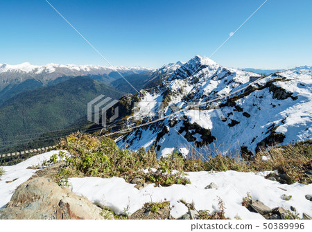 Suspension footbridge in the high snowy mountains. Suspension footbridge in the high snowy mountains. 50389996