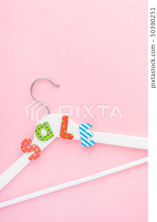 White hangers with sale text on pink background White hangers with sale text on pink background 50390251