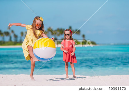 Little adorable girls playing on beach with air ball 50391170