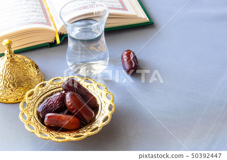 Still life Organic dates, cup of pure drinking water and quran book. Iftar Ramadan concept Still life Organic dates, cup of pure drinking water and quran book. Iftar Ramadan concept 50392447