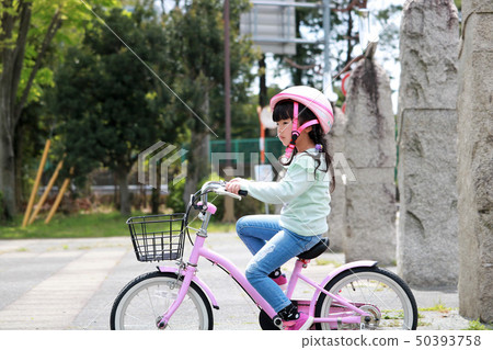 A girl riding a bicycle A girl riding a bicycle 50393758