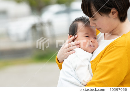 抱著嬰孩日本父母和孩子的一個年輕母親 抱著嬰孩日本父母和孩子的一個年輕母親 50397066