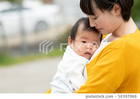 抱著嬰孩日本父母和孩子的一個年輕母親 抱著嬰孩日本父母和孩子的一個年輕母親 50397068
