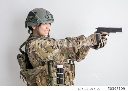 穿著在白色背景的一個涼快的女孩偽裝服裝是與槍的生存比賽 50397109