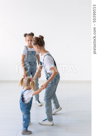 Family and love concept - Three sisters hugging over white background Family and love concept - Three sisters hugging over white background 50399553