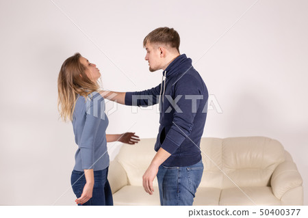 People, abuse and violence concept - aggressive man strangling his wife People, abuse and violence concept - aggressive man strangling his wife 50400377