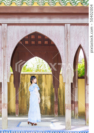 A woman in a light blue dress traveling abroad A woman in a light blue dress traveling abroad 50402804