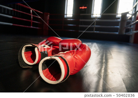 Pair of red boxing gloves in Boxing ring 50402836