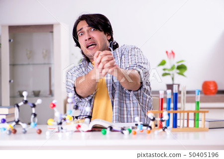 Young student physicist preparing for exam at home Young student physicist preparing for exam at home 50405196