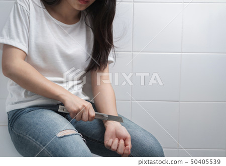 Desperate woman trying to kill herself with knife 50405539