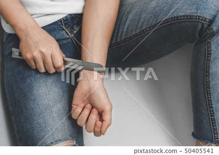 Desperate woman trying to kill herself with knife 50405541
