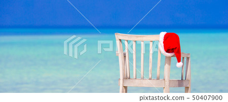 Red santa hat on beach chair at tropical vacation Red santa hat on beach chair at tropical vacation 50407900