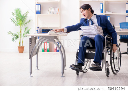 Young male employee in wheelchair working in the office  50410294