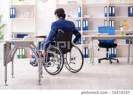 Young male employee in wheelchair working in the office  50410295