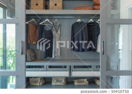 modern closet with clothes hanging 50410730