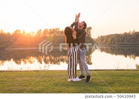 Romantic, social dance and people concept - young couple dancing a tango or bachata near the lake Romantic, social dance and people concept - young couple dancing a tango or bachata near the lake 50410943