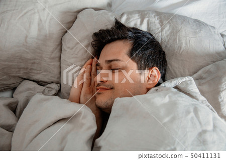 Yound man sleep in a bed at home. 50411131