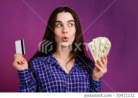 Pensive woman with credit card and dollar bills Pensive woman with credit card and dollar bills 50411132