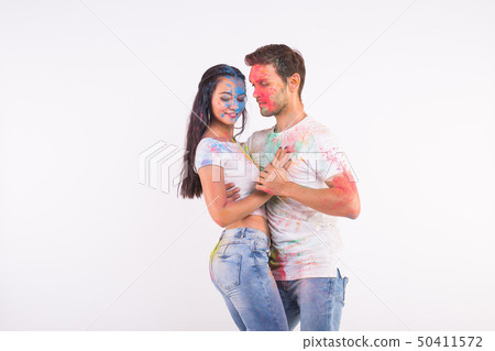Friendship, social dance, love, festival of holi, people concept - young couple playing with colors Friendship, social dance, love, festival of holi, people concept - young couple playing with colors 50411572