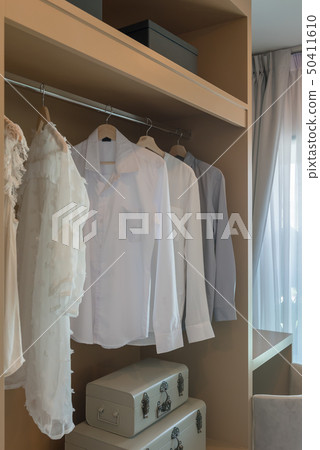 modern closet with clothes hanging 50411610
