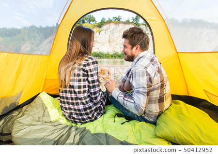 people, summer tourism and nature concept - young couple resting in camping tent, view from inside people, summer tourism and nature concept - young couple resting in camping tent, view from inside 50412952