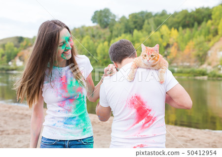 Festival holi, tourism and nature concept - Portrait of woman and man with cat covered multi-colored 50412954