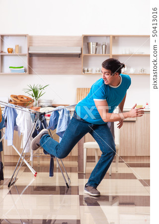 Young man husband doing clothing ironing at home  50413016