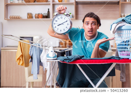 Young man husband doing clothing ironing at home Young man husband doing clothing ironing at home 50413260