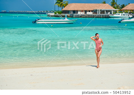 Woman in one-piece swimsuit at beach 50413952