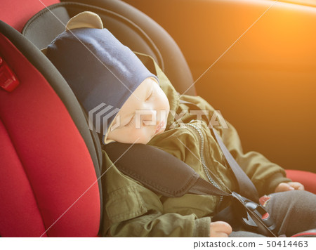Close Up caucasian cute baby boy sleeping in modern car seat. Child traveling safety on the road Close Up caucasian cute baby boy sleeping in modern car seat. Child traveling safety on the road 50414463