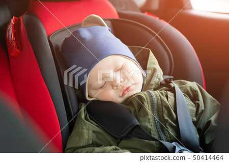 Close Up caucasian cute baby boy sleeping in modern car seat. Child traveling safety on the road Close Up caucasian cute baby boy sleeping in modern car seat. Child traveling safety on the road 50414464