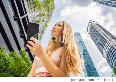 woman using map app on smartphone on the background of skyscrapers woman using map app on smartphone on the background of skyscrapers 50417801