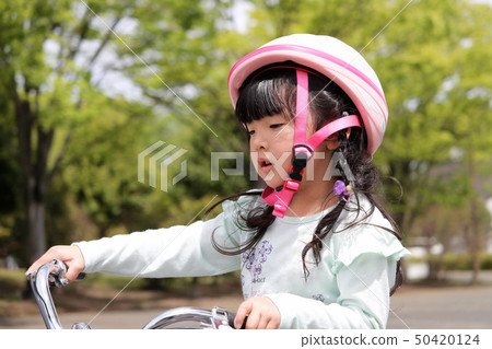 A girl riding a bicycle 50420124