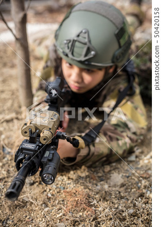 穿著迷彩制服的女孩玩與氣槍的生存比賽 50420158
