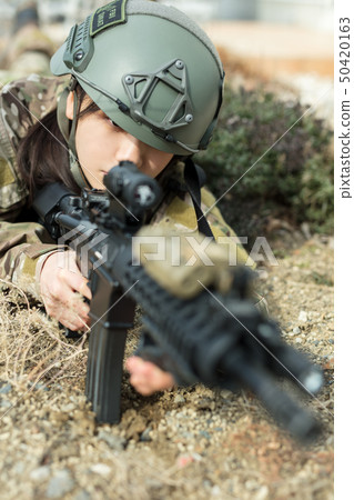 穿著迷彩制服的女孩玩與氣槍的生存比賽 50420163