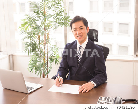 商人坐在辦公桌前 50421180