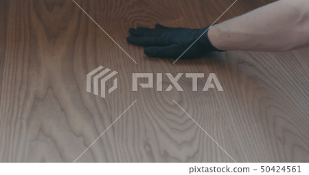 closeup man hand touches ash wood floor 50424561
