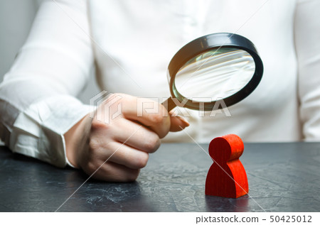Business woman examines a red man's figure  50425012