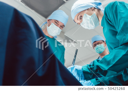 Team of surgeons in operation room during surgery 50425268