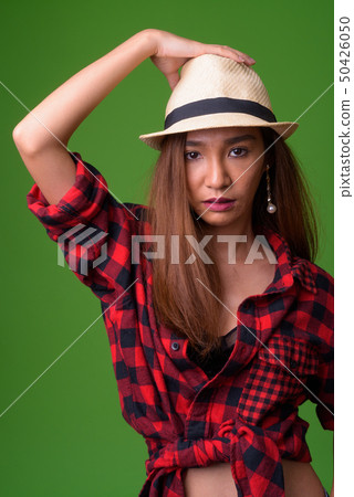 Young slim Asian woman against green background 50426050